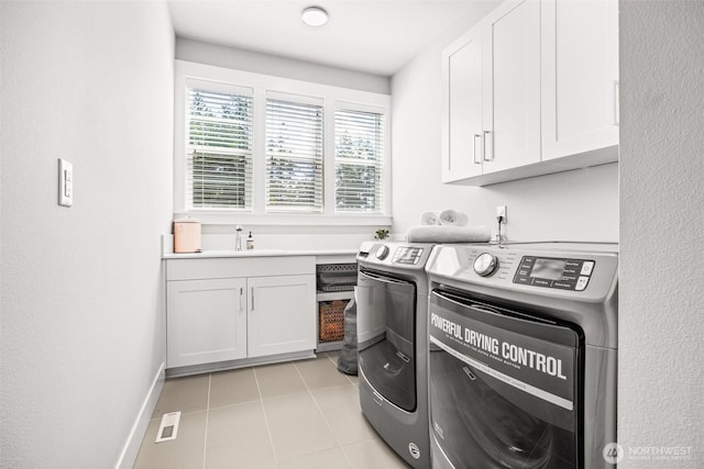 21888 SE 5th Pl, Sammamish, WA 98074 - laundry area featuring washing machine and dryer, cabinet space, light tile patterned flooring, and baseboards
