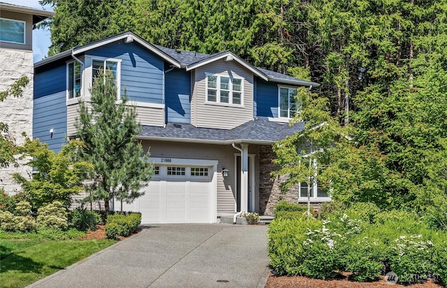 21888 SE 5th Pl, Sammamish, WA 98074 - view of front of home with driveway, an attached garage, a shingled roof, and stone siding