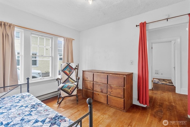 1228 22nd Ave, Longview, WA 98632 - bedroom featuring a baseboard radiator and wood finished floors