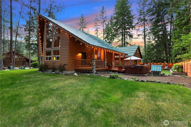 18880 Pine Loop, Leavenworth, WA 98826 - back of house at dusk with a hot tub, a lawn, and metal roof