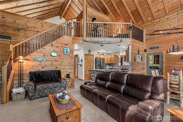 18880 Pine Loop, Leavenworth, WA 98826 - living room with wood walls, high vaulted ceiling, stairway, light colored carpet, and wood ceiling with exposed beams