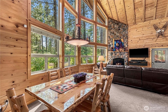 18880 Pine Loop, Leavenworth, WA 98826 - carpeted dining space with wood ceiling, wooden walls, high vaulted ceiling, and a stone fireplace