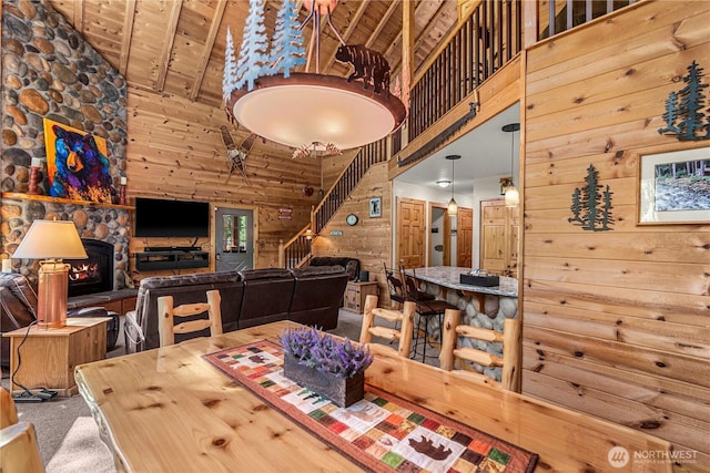 18880 Pine Loop, Leavenworth, WA 98826 - dining area featuring high vaulted ceiling, wooden walls, stairway, wooden ceiling, and a fireplace