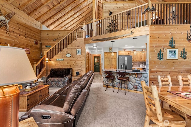18880 Pine Loop, Leavenworth, WA 98826 - living area featuring wooden walls, high vaulted ceiling, carpet, wooden ceiling, and stairway