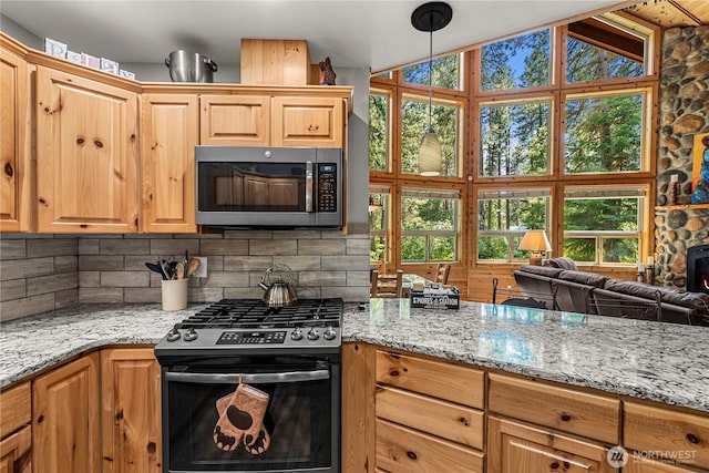 18880 Pine Loop, Leavenworth, WA 98826 - kitchen featuring stainless steel appliances, backsplash, light stone counters, open floor plan, and vaulted ceiling