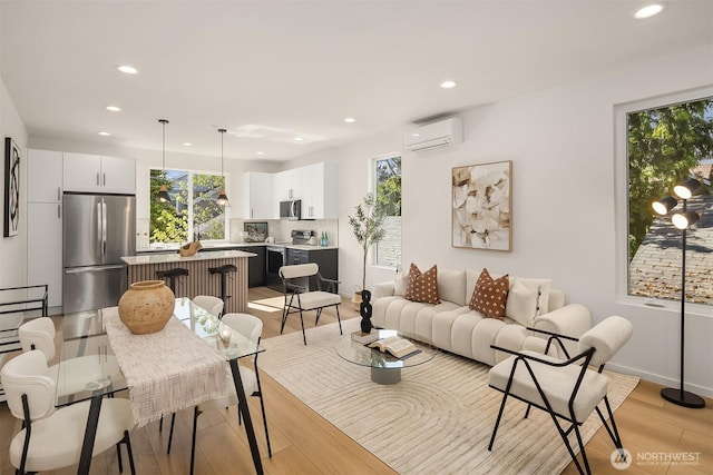 8513 19th Ave NW Unit A, Seattle, WA 98117 - living room featuring a wall unit AC, recessed lighting, healthy amount of natural light, light wood-type flooring, and baseboards