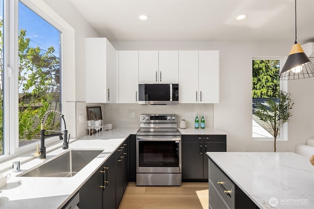 8513 19th Ave NW Unit A, Seattle, WA 98117 - kitchen with stainless steel appliances, a sink, plenty of natural light, decorative backsplash, and recessed lighting