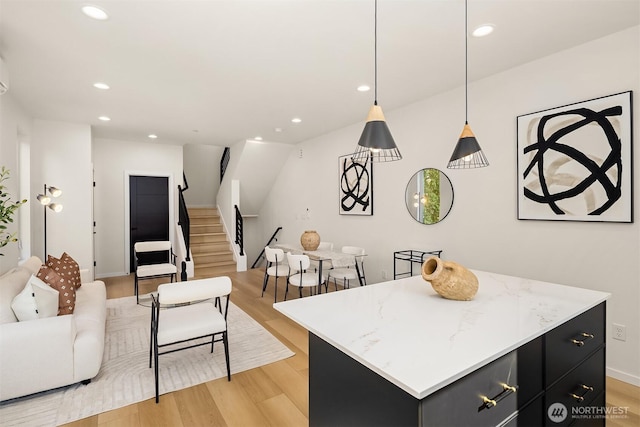8513 19th Ave NW Unit A, Seattle, WA 98117 - kitchen with open floor plan, dark cabinetry, a kitchen island, light wood-style flooring, and recessed lighting