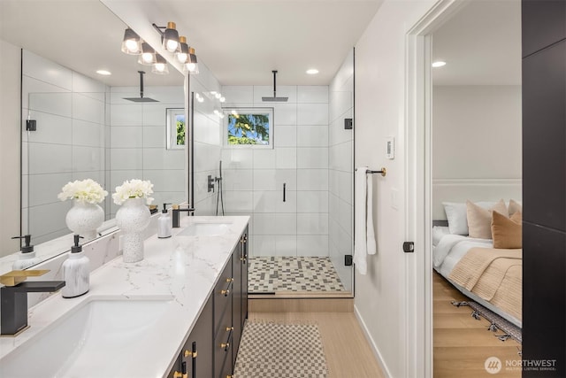 8513 19th Ave NW Unit A, Seattle, WA 98117 - bathroom featuring double vanity, a shower stall, wood finished floors, recessed lighting, and baseboards