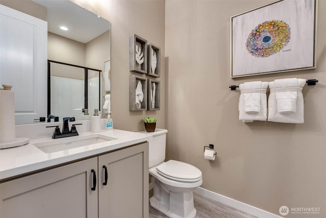 20332 150th St E Unit 589, Bonney Lake, WA 98391 - bathroom with vanity, toilet, wood finished floors, baseboards, and a shower with shower door