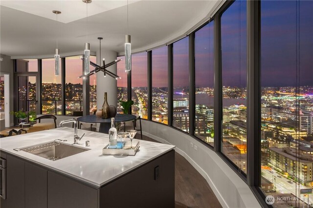 2510 6th Ave Unit 2802, Seattle, WA 98121 - bar area featuring a sink, a city view, dark wood-style floors, baseboards, and hanging light fixtures