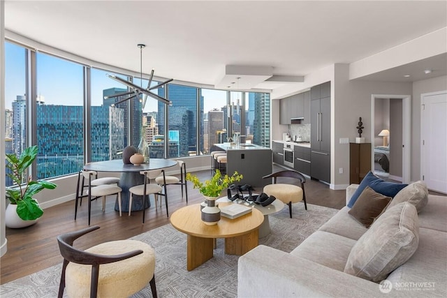 2510 6th Ave Unit 2802, Seattle, WA 98121 - living room featuring wood finished floors, baseboards, a skyline view, washer / clothes dryer, and a chandelier