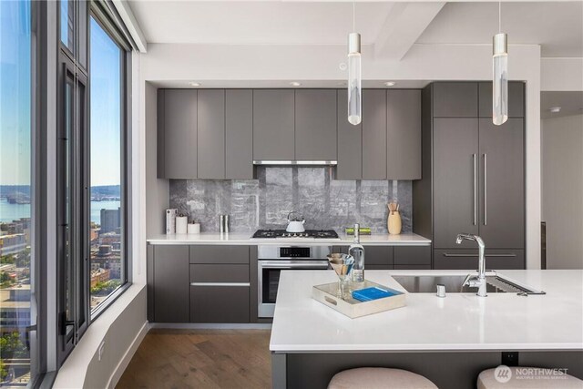 2510 6th Ave Unit 2802, Seattle, WA 98121 - kitchen featuring gray cabinetry, appliances with stainless steel finishes, modern cabinets, and dark wood-type flooring