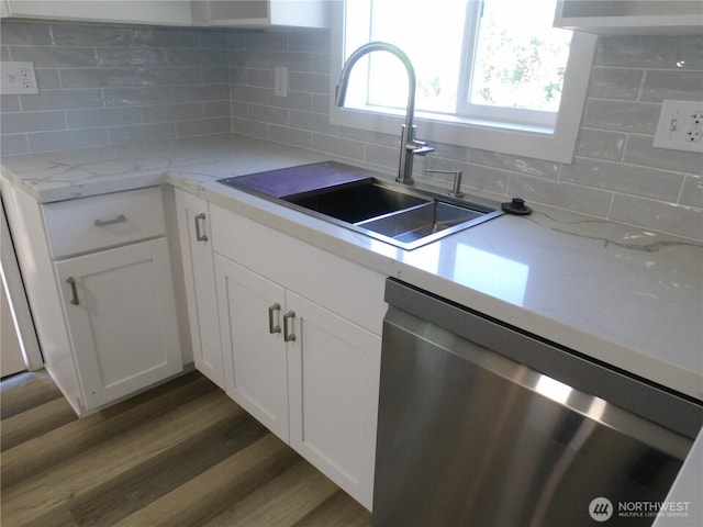 1707 258th Pl, Ocean Park, WA 98640 - kitchen with stainless steel dishwasher, a sink, white cabinets, and decorative backsplash
