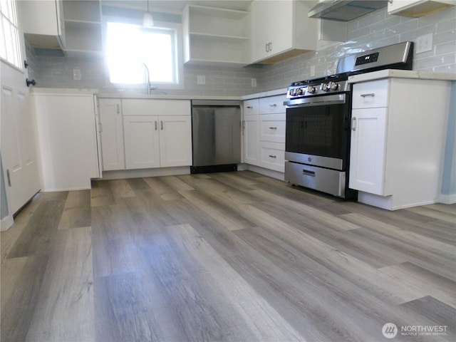 1707 258th Pl, Ocean Park, WA 98640 - kitchen featuring appliances with stainless steel finishes, range hood, white cabinetry, and backsplash
