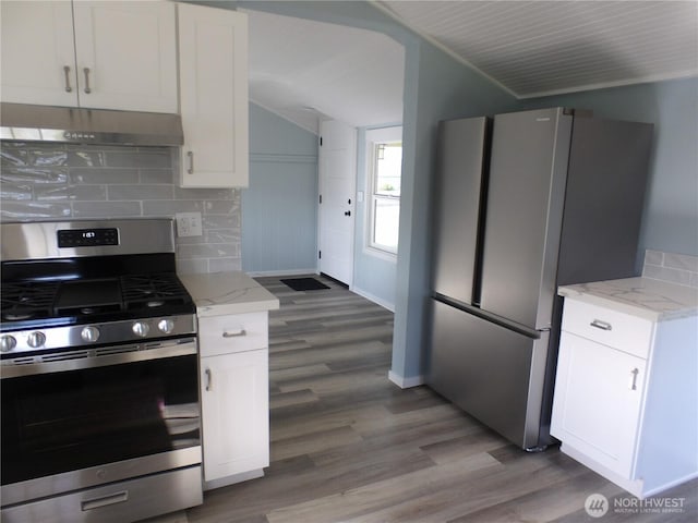 1707 258th Pl, Ocean Park, WA 98640 - kitchen with appliances with stainless steel finishes, under cabinet range hood, lofted ceiling, wood finished floors, and white cabinets