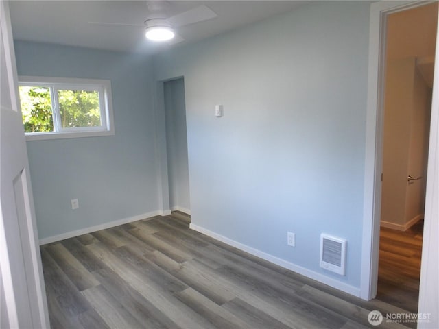 1707 258th Pl, Ocean Park, WA 98640 - unfurnished bedroom with dark wood-style flooring, baseboards, and a ceiling fan