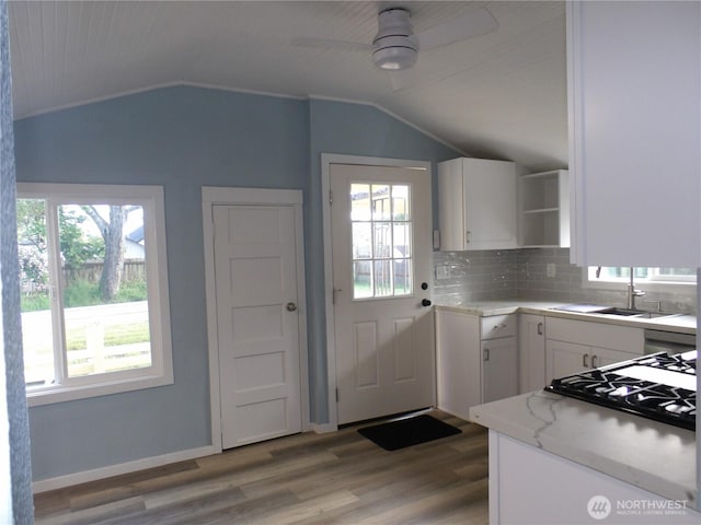 1707 258th Pl, Ocean Park, WA 98640 - kitchen with a sink, open shelves, vaulted ceiling, white cabinetry, and healthy amount of natural light