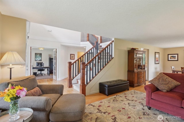 8906 NE 275th St, Battle Ground, WA 98604 - living room featuring stairs, light wood finished floors, and a textured ceiling