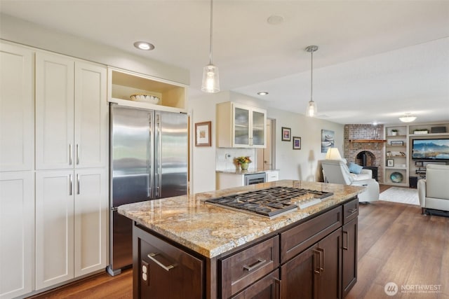 8906 NE 275th St, Battle Ground, WA 98604 - kitchen featuring appliances with stainless steel finishes, white cabinetry, wood finished floors, a fireplace, and recessed lighting