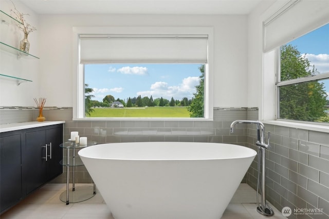 8906 NE 275th St, Battle Ground, WA 98604 - full bathroom featuring tile walls, tile patterned flooring, a freestanding tub, vanity, and a wainscoted wall