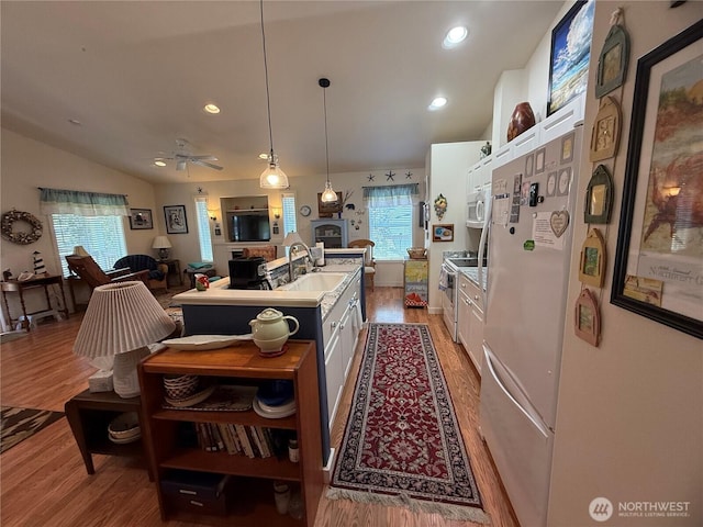 30511 M Pl, Ocean Park, WA 98640 - kitchen with white cabinets, vaulted ceiling, light wood-type flooring, a sink, and recessed lighting