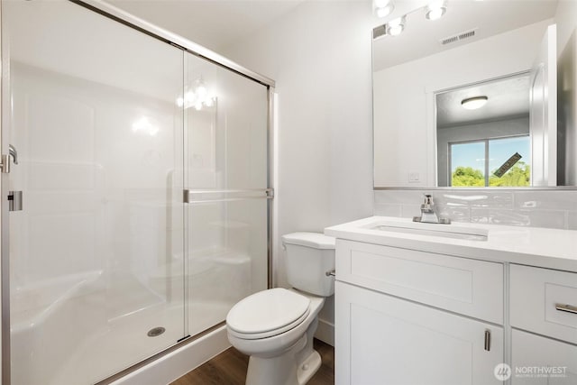 311 W Sandy Loop, Moses Lake, WA 98837 - bathroom with vanity, a stall shower, wood finished floors, and decorative backsplash