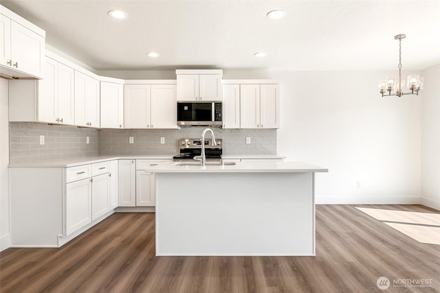 311 W Sandy Loop, Moses Lake, WA 98837 - kitchen featuring appliances with stainless steel finishes, light countertops, wood finished floors, and recessed lighting