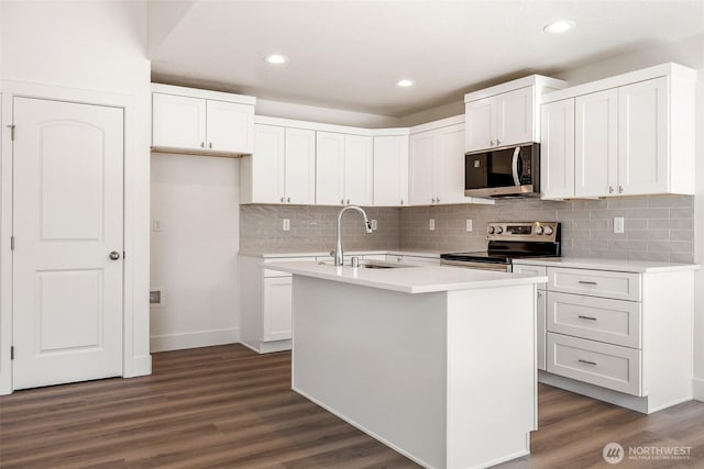 311 W Sandy Loop, Moses Lake, WA 98837 - kitchen with appliances with stainless steel finishes, dark wood-style floors, a kitchen island with sink, backsplash, and recessed lighting