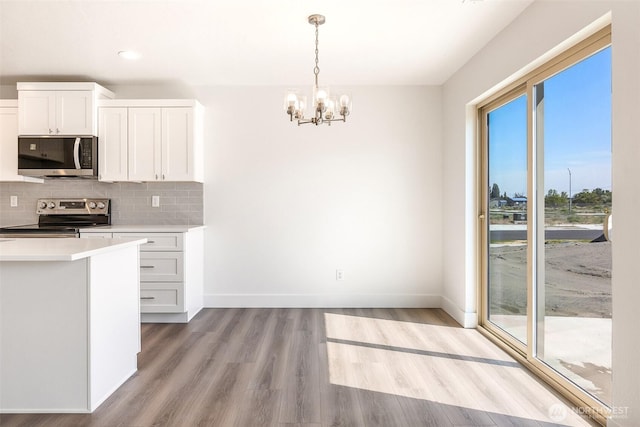 311 W Sandy Loop, Moses Lake, WA 98837 - kitchen featuring appliances with stainless steel finishes, a chandelier, light wood-style flooring, decorative backsplash, and light countertops
