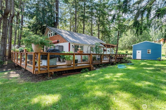 711 E Herron Blvd NW, Lakebay, WA 98349 - rear view of property featuring a wooden deck, metal roof, a yard, and an outbuilding