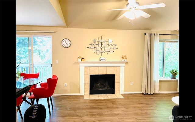 1009 112th St Unit D304, Everett, WA 98208 - living room featuring a tile fireplace, ceiling fan, wood finished floors, and baseboards