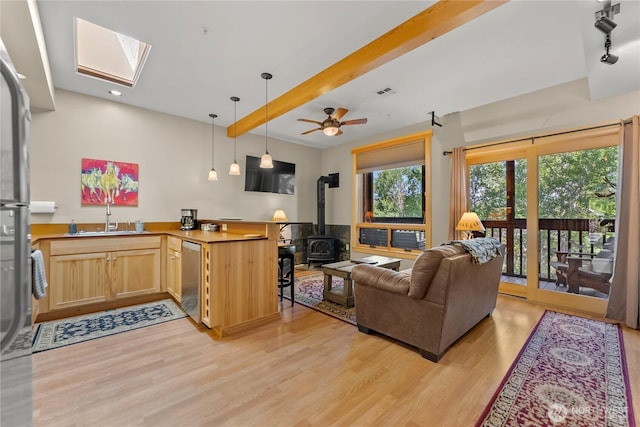 140 Twisp Ave W Unit 204, Twisp, WA 98856 - living room featuring a wood stove, light wood-type flooring, a skylight, beam ceiling, and recessed lighting
