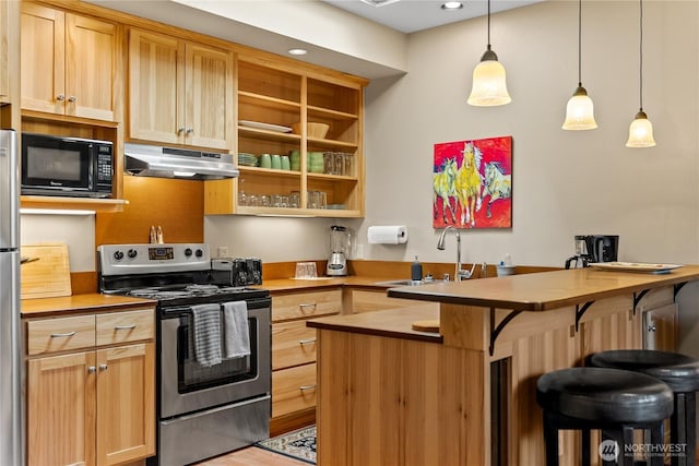 140 Twisp Ave W Unit 204, Twisp, WA 98856 - kitchen featuring appliances with stainless steel finishes, under cabinet range hood, a sink, a kitchen breakfast bar, and pendant lighting