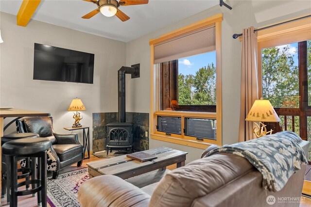 140 Twisp Ave W Unit 204, Twisp, WA 98856 - living area featuring a wood stove, plenty of natural light, a ceiling fan, and wood finished floors