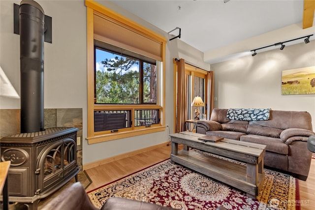 140 Twisp Ave W Unit 204, Twisp, WA 98856 - living area featuring a wood stove, wood finished floors, track lighting, and baseboards