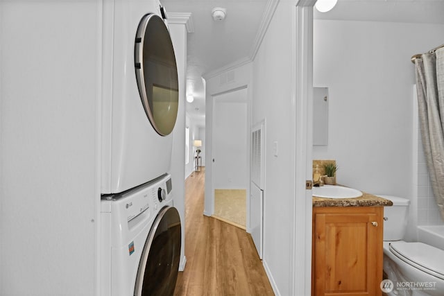 23708 Locust Way Unit 26B, Bothell, WA 98021 - washroom featuring stacked washer / dryer, wood finished floors, and crown molding