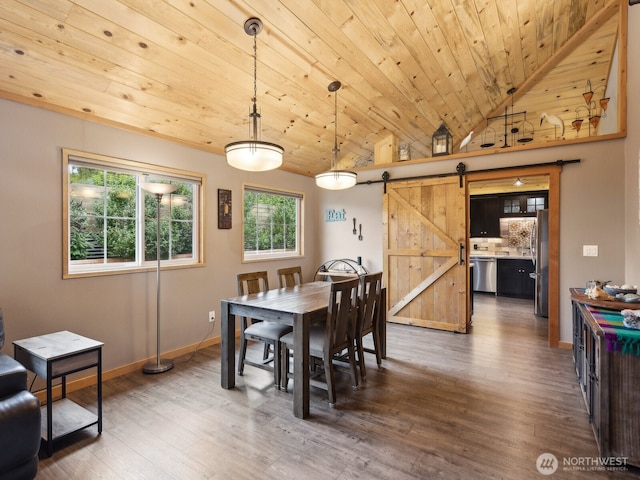 957 SW Camano Dr, Camano Island, WA 98282 - dining space with a barn door, wood ceiling, wood finished floors, baseboards, and vaulted ceiling