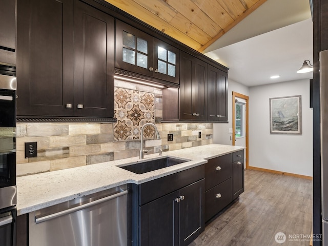 957 SW Camano Dr, Camano Island, WA 98282 - kitchen with stainless steel dishwasher, a sink, tasteful backsplash, baseboards, and wood finished floors
