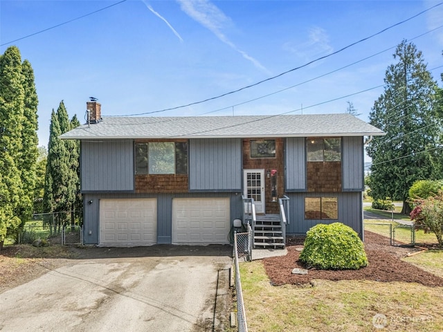 7391 E Grandview St, Port Orchard, WA 98366 - bi-level home with roof with shingles, concrete driveway, a chimney, and an attached garage