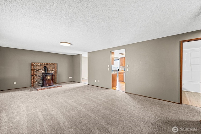 7391 E Grandview St, Port Orchard, WA 98366 - unfurnished living room with light carpet, a wood stove, a textured ceiling, and baseboards