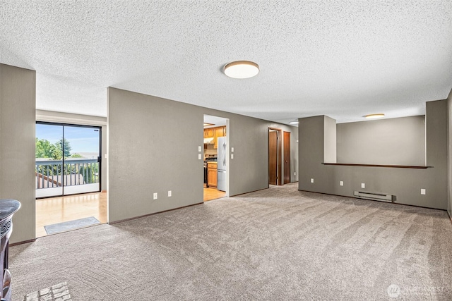 7391 E Grandview St, Port Orchard, WA 98366 - carpeted empty room with baseboard heating, a textured ceiling, and baseboards