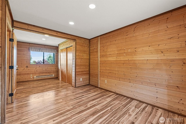 7391 E Grandview St, Port Orchard, WA 98366 - spare room featuring a baseboard heating unit, light wood-style floors, wood walls, and recessed lighting