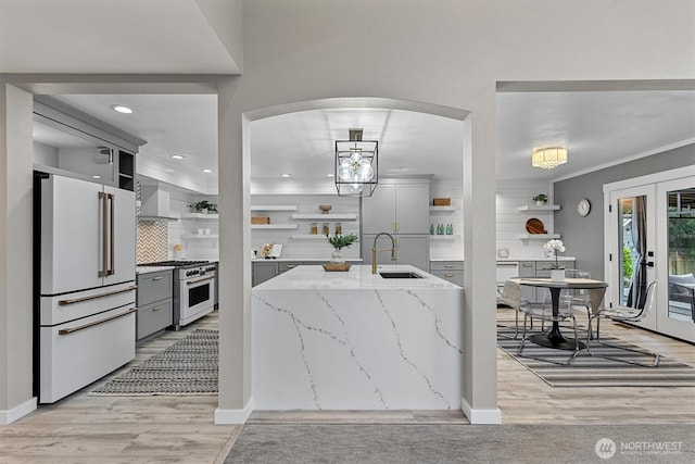 31632 19th Dr NW, Stanwood, WA 98292 - kitchen featuring open shelves, premium appliances, a sink, wall chimney exhaust hood, and gray cabinets