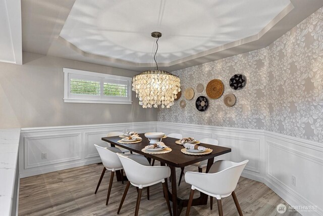 31632 19th Dr NW, Stanwood, WA 98292 - dining room with wainscoting, light wood-style flooring, a chandelier, and a raised ceiling