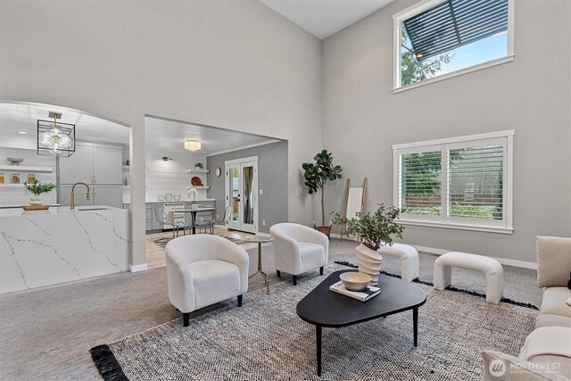 31632 19th Dr NW, Stanwood, WA 98292 - carpeted living room with a towering ceiling, a sink, baseboards, and arched walkways