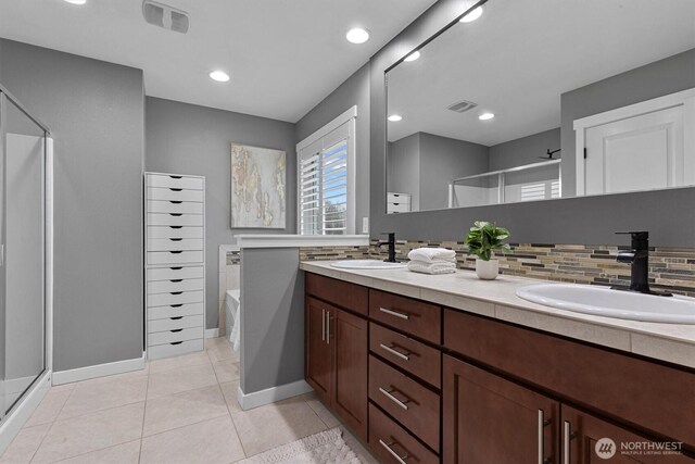 31632 19th Dr NW, Stanwood, WA 98292 - full bathroom with a shower stall, double vanity, a bath, tasteful backsplash, and baseboards