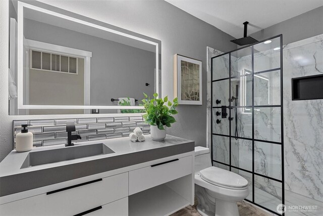 31632 19th Dr NW, Stanwood, WA 98292 - bathroom with vanity, toilet, a marble finish shower, and wood finished floors