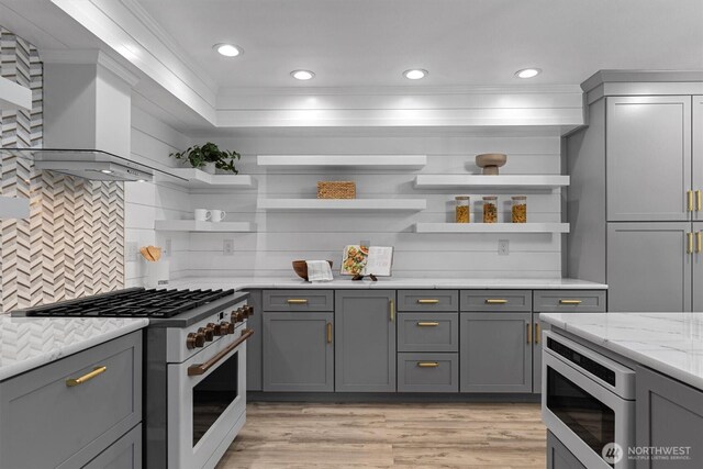 31632 19th Dr NW, Stanwood, WA 98292 - kitchen with high end white range, open shelves, stainless steel microwave, crown molding, and gray cabinetry
