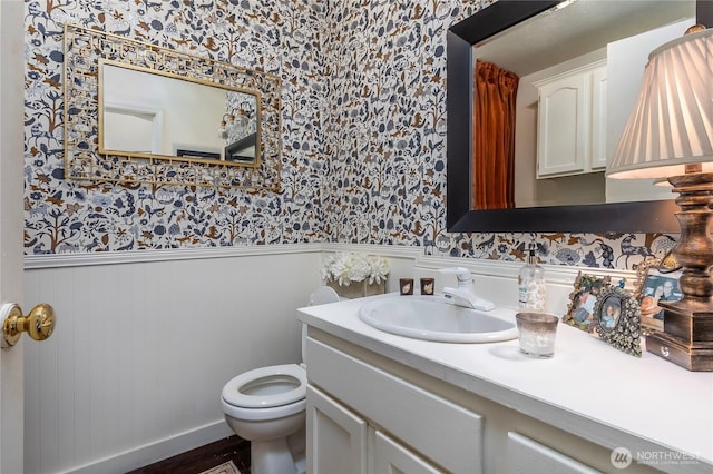 239 Alpine Dr, Packwood, WA 98361 - bathroom featuring wallpapered walls, a wainscoted wall, toilet, and vanity